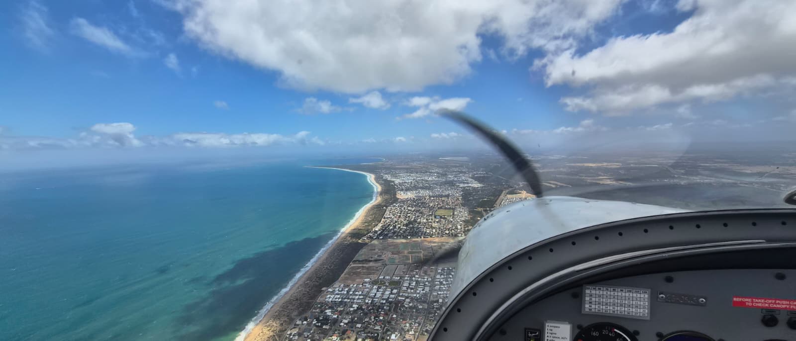 Cockpit view over coastal city and beach